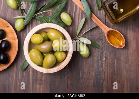 Olives, huile d'oilive et brunchs sur la table en bois, Banque D'Images