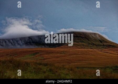 Des nuages au-dessus de l'un des sommets des Brecon Beacons sur l'A467, au Pays de Galles, Royaume-Uni. Samedi 26 Octobre 2019 Banque D'Images