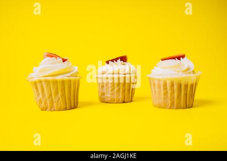 Les gâteaux avec crème blanche et remplissage de fraise sur un fond jaune. La boulangerie et sucreries. Banque D'Images