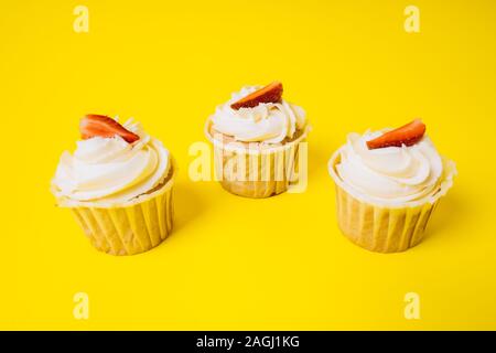 Les gâteaux avec crème blanche et remplissage de fraise sur un fond jaune. La boulangerie et sucreries. Banque D'Images