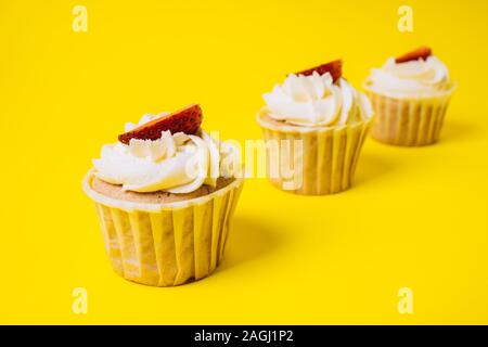 Les gâteaux avec crème blanche et remplissage de fraise sur un fond jaune. La boulangerie et sucreries. Banque D'Images