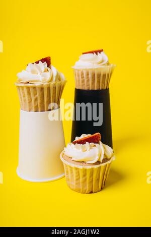 Les gâteaux avec crème blanche et remplissage de fraise sur un fond jaune. La boulangerie et sucreries. Banque D'Images