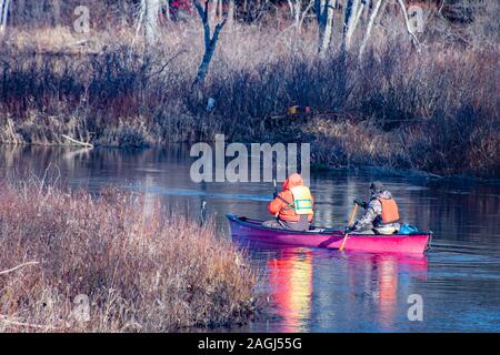 Deux hommes à bord de canots des chasseurs de canards dans la rivière Sacandaga près de spéculateur, NY USA dans les Adirondacks au début de l'hiver Banque D'Images