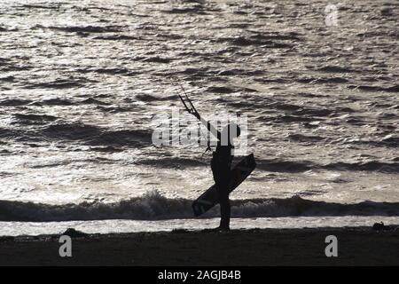 Kitesurf Exmouth, Kitesurfer découpé sur la mer argentée sur une journée l'hiver. Devon, UK Banque D'Images