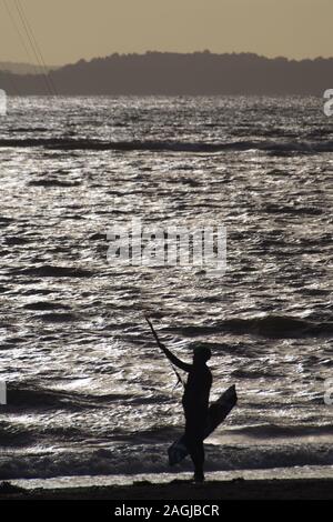 Kitesurf Exmouth, Kitesurfer découpé sur la mer argentée sur une journée l'hiver. Devon, UK Banque D'Images