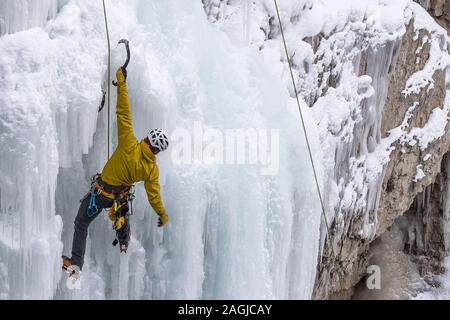 Le parc national Banff, Alberta, Canada - le 15 décembre 2019 : un grimpeur sur glace masculin solo travaille son chemin jusqu'frozen chutes supérieures à Johnston Canyon Banque D'Images