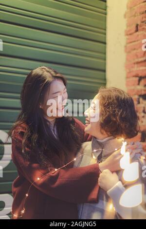 Happy asian mère âgée et sa fille adulte se regardant à Portland Pearl district nuit Banque D'Images