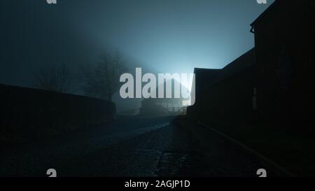 Une sombre moody country road aller dans la distance, à côté des bâtiments de ferme retour sur un hivers brumeux éclairé la nuit. Banque D'Images