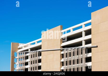 Vue extérieure du garage de stationnement multi niveaux typique sous façade bleu ciel. Banque D'Images