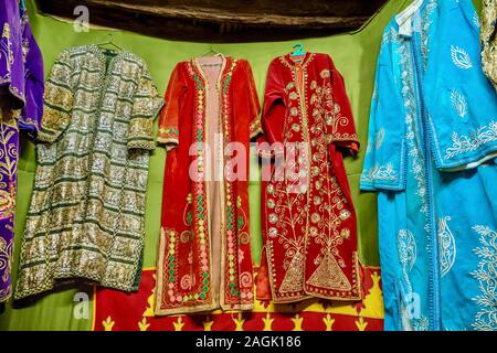 Une exposition de vêtements traditionnels marocains vintage, avec des couleurs vibrantes et des motifs brodés. Banque D'Images