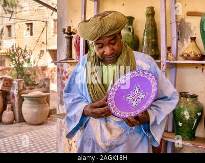 Tamegroute, Maroc - 24 octobre 2015. Un vendeur marocain expliquant le processus de la poterie à l'extérieur d'un atelier qui s'est régulièrement visité par de Banque D'Images