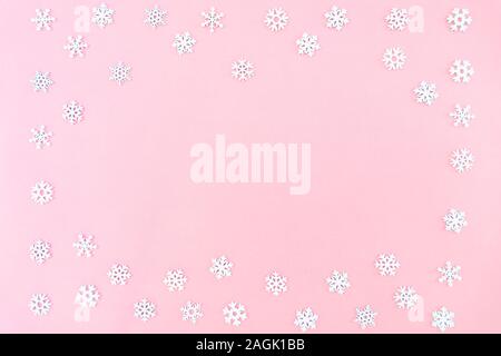 Composition de Noël. Flocons de Noël sur fond rose. Mise à plat, vue du dessus, copy space Banque D'Images