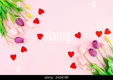 Composition de la Saint-Valentin. Tulip fleurs et coeurs rouges sur fond rose. La Saint-Valentin, fête des Mères concept. Mise à plat, vue du dessus, copy space Banque D'Images