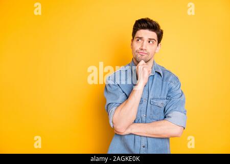 Photo de l'homme intéressées pensive à la recherche dans l'espace vide qui envisagent de nouvelles idées créatrices de toucher sa peau couleur de fond vibrant isolé Banque D'Images