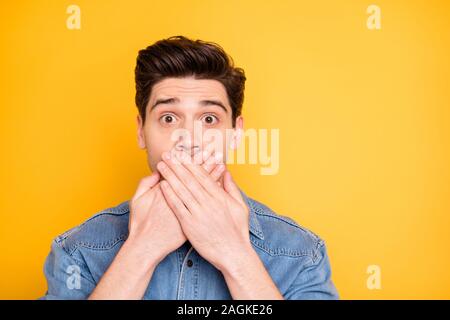 La photo en gros plan de l'homme étonné couvrant sa bouche après avoir dit qu'il ne devrait pas avoir avec les yeux ouverts large couleur vive isolé Banque D'Images