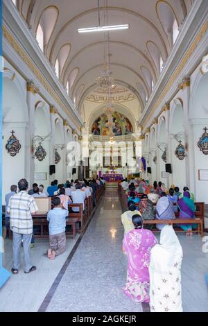 Vue arrière des gens prier à l'intérieur de Notre Dame de la cathédrale de l'Immaculée Conception de Pondichéry, Tamil Nadu, Inde Banque D'Images