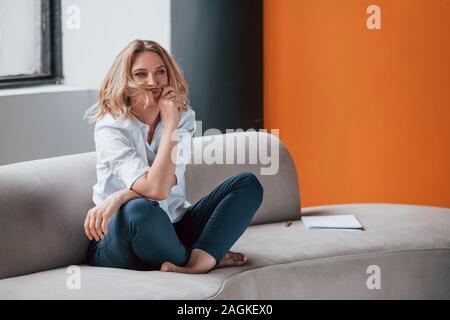Photo pleine longueur. Businesswoman avec cheveux blonds siégeant à la salle la fenêtre contre Banque D'Images