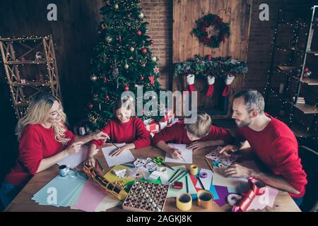 Photo de grande famille Père Mère Frère Soeur prévues x-mas matin en famille les parents d'aider à l'écriture du père noël, lettre à l'intérieur de la table de séance souhaite Banque D'Images