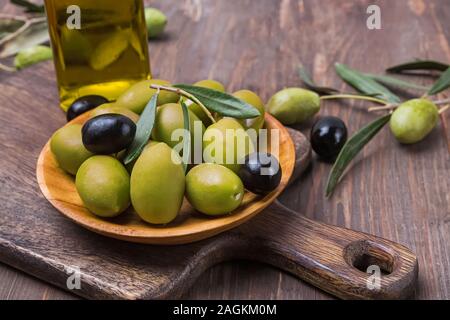 Olives vertes et noires dans les petites plaques en bois Banque D'Images