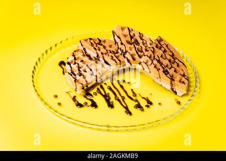 Gaufres avec du chocolat sur fond jaune. Banque D'Images