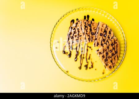 Gaufres avec du chocolat sur fond jaune. Banque D'Images