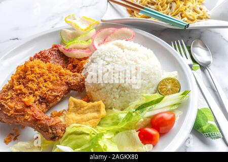 Penyet Ayam est une cuisine de l'Est javanais indonésien - composé de poulet frit, c'est écrasé au pilon Mortier contre pour l'assouplir, servi Banque D'Images