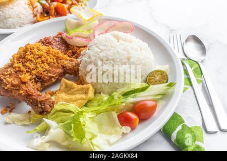 Penyet Ayam est une cuisine de l'Est javanais indonésien - composé de poulet frit, c'est écrasé au pilon Mortier contre pour l'assouplir, servi Banque D'Images