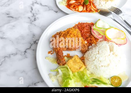 Penyet Ayam est une cuisine de l'Est javanais indonésien - composé de poulet frit, c'est écrasé au pilon Mortier contre pour l'assouplir, servi Banque D'Images