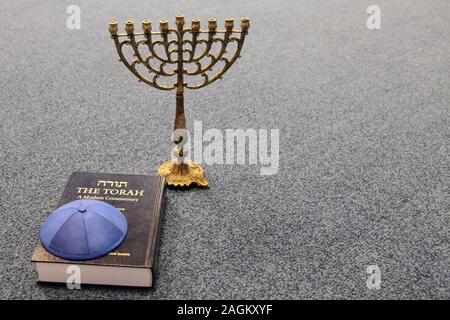 Une menorah juive se dresse sur un tapis à côté de la Torah et de la kippa juive bleu (CAP) Banque D'Images