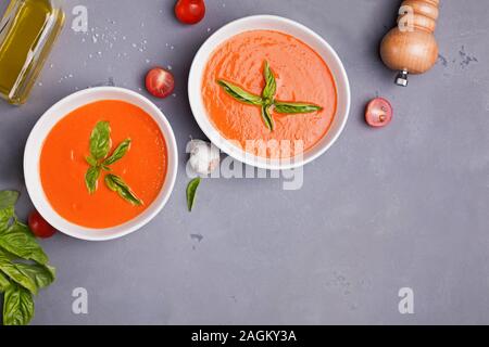 Soupe de tomate dans des bols sur la table en pierre grise Banque D'Images