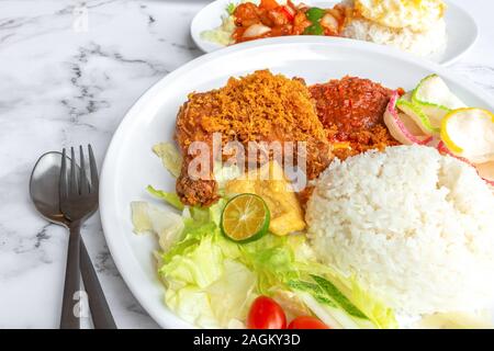 Penyet Ayam est une cuisine de l'Est javanais indonésien - composé de poulet frit, c'est écrasé au pilon Mortier contre pour l'assouplir, servi Banque D'Images