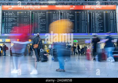 20 décembre 2019, Hessen, Frankfurt/Main : Les passagers passent devant l'écran de sélection dans le Terminal 1 de l'aéroport. Une augmentation du nombre de passagers est attendue dans les prochains jours. Photo : Boris Roessler/dpa Banque D'Images