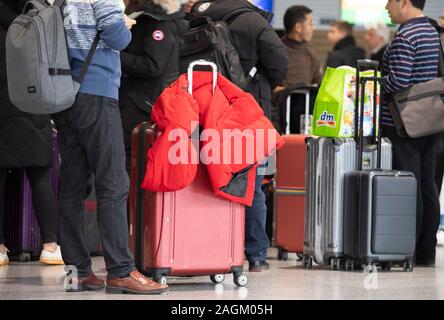 20 décembre 2019, Hessen, Frankfurt/Main : Les passagers attendent leur arrivée au comptoir d'en dessous de l'écran de sélection dans le Terminal 1 de l'aéroport. Une augmentation du nombre de passagers est attendue dans les prochains jours. Photo : Boris Roessler/dpa Banque D'Images