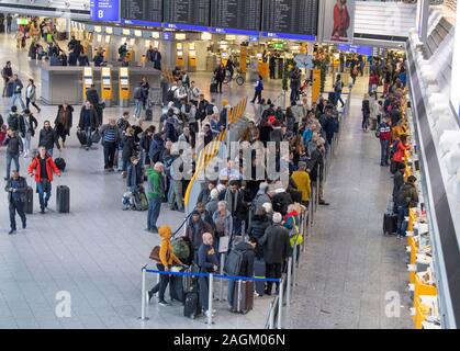 20 décembre 2019, Hessen, Frankfurt/Main : Les passagers attendent leur arrivée au comptoir d'en dessous de l'écran de sélection dans le Terminal 1 de l'aéroport. Une augmentation du nombre de passagers est attendue dans les prochains jours. Photo : Boris Roessler/dpa Banque D'Images