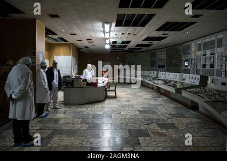 Employés de la centrale nucléaire de Tchernobyl qui travaillent dans la salle de contrôle du réacteur de Tchernobyl 2. La salle des opérations n'a toujours ses écrans et panneaux d'affichage d'origine de boutons de commande. Centrale nucléaire de Tchernobyl, Tchernobyl, Ivankiv, Kiev Kiev oblast, Ukraine, Europe Banque D'Images