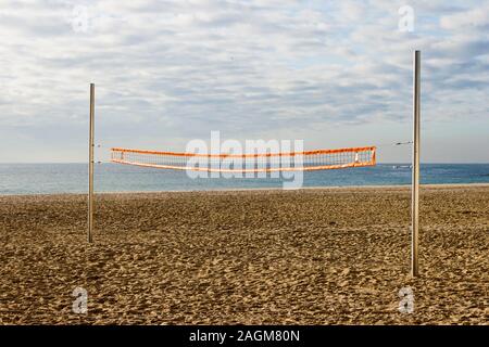 Filet de volley-ball de plage dans une cour vide dans un jour nuageux le matin sur la côte. Banque D'Images