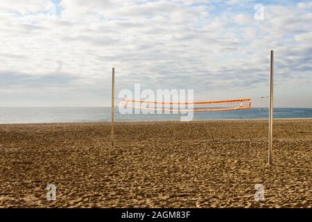 Filet de volley-ball de plage dans une cour vide dans un jour nuageux le matin sur la côte. Banque D'Images