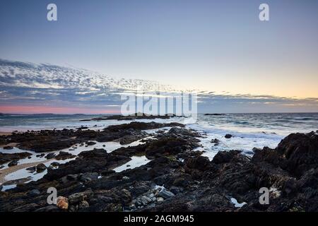 Le début du lever du soleil avec le soleil sous l'horizon sur la côte de Sawtell regardant vers l'océan Pacifique, Nouvelle-Galles du Sud, Australie Banque D'Images