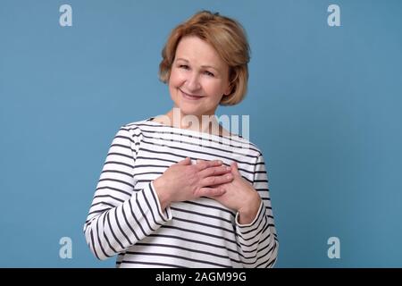 Femme mature blonde avec des cheveux bouclés d'être touché avec b compliment Banque D'Images