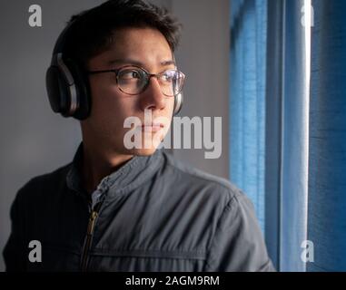 Jeune homme sur des verres d'écouter de la musique avec des écouteurs Banque D'Images