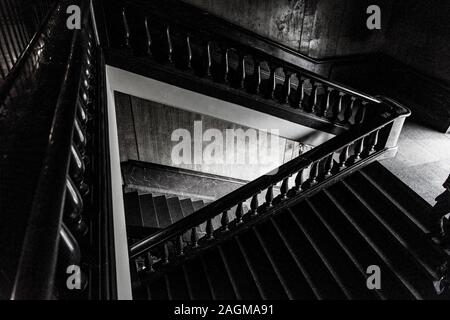 Vue en niveaux de gris intérieure d'un escalier descendant Banque D'Images