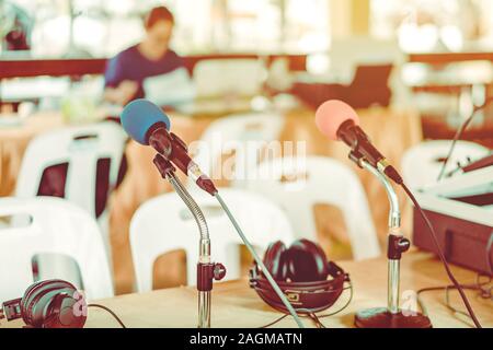 Deux microphones avec éponges bleu et rouge sur un support placé avec écouteurs sur la table avec l'image du barbouillage du technicien audio a été l'installation et le sev Banque D'Images