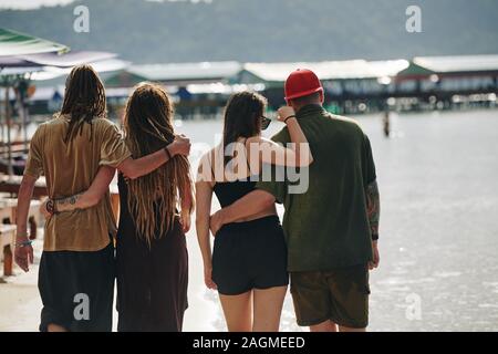 Vue arrière du bras deux jeunes couples walking in the beach le jour de l'été et profiter de passer des vacances ensemble Banque D'Images