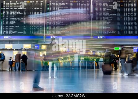 20 décembre 2019, Hessen, Frankfurt/Main : Les passagers passent devant l'écran de sélection dans le Terminal 1 de l'aéroport. Une augmentation du nombre de passagers est attendue dans les prochains jours. Photo : Boris Roessler/dpa Banque D'Images