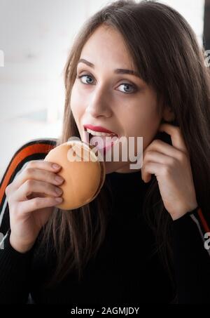 Girl au fast food restaurant tout en mangeant un hamburger Banque D'Images