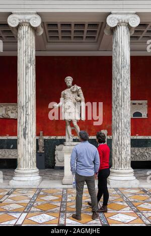 Glyptotek de Copenhague, vue arrière d'un couple l'étude d'une statue de l'empereur Marc Aurèle dans l'intérieur de la colonnade Kampmann Glyptotek, Copenhague Banque D'Images