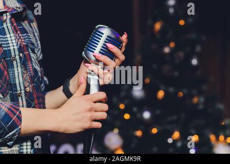 La femme tenant un seul microphone rétro arrière-plan coloré contre Banque D'Images