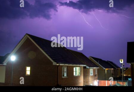 Un ciel d'orage, la nuit, sur un lotissement en Angleterre, Royaume-Uni. Banque D'Images