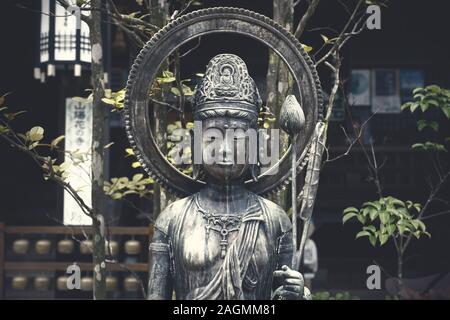 Statue de Bouddha avec des feuilles vertes et des cloches à Daishion temple à Miyashima, Japon Banque D'Images