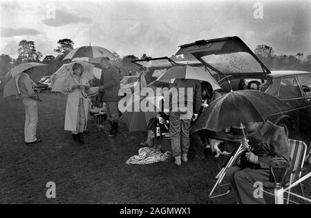 Mauvais temps Royaume-Uni 1980s personnes au cowards Park Polo Club 1981 pique-nique en plein air lors d'une pause déjeuner UK HOMER SYKES Banque D'Images